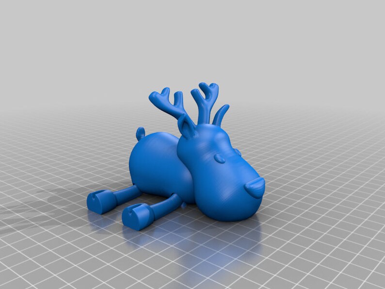 May include: A blue cartoon reindeer figurine with large antlers, small ears, and stubby legs. The reindeer is lying down, with its legs extended. The figurine has a smooth, matte finish and is set against a neutral background.