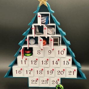 May include: A teal blue Christmas tree shaped advent calendar with 24 numbered doors. The doors are white with red numbers. The tree is decorated with a gold star on top. There are small gifts and spools of thread visible inside some of the doors.