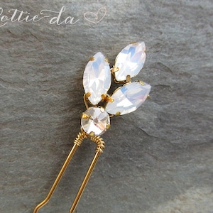 May include: Gold hair comb with a cluster of iridescent white rhinestones in a leaf design.