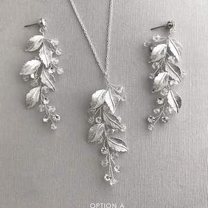 May include: Silver bridal jewelry set with a delicate leaf design and crystal accents. The set includes a necklace and a pair of earrings.