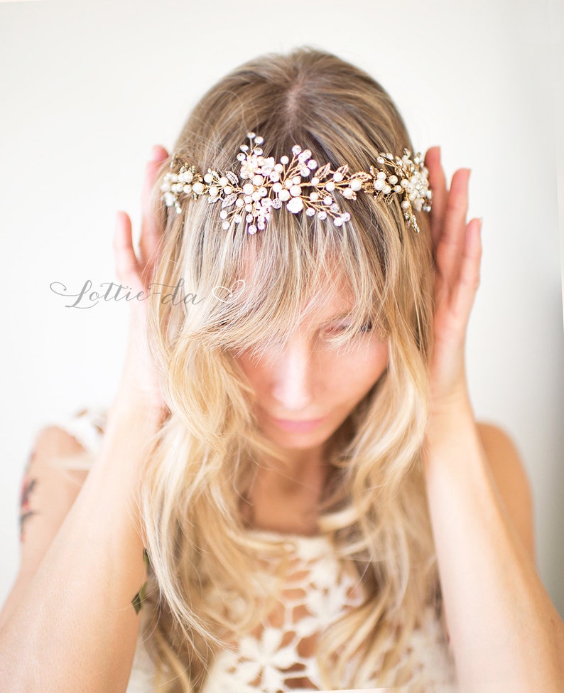 Pu&ograve; includere: Un fermaglio per capelli da sposa dorato con dettagli in perle e cristalli. Il fermaglio &egrave; progettato con un motivo floreale ed &egrave; indossato da una donna con lunghi capelli biondi.