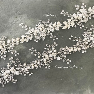 Pu&ograve; includere: Quattro pettini per capelli argentati con decorazioni di perle e cristalli. I pettini sono disposti in fila su uno sfondo grigio. Il testo "Silver" e "Antique Silver" &egrave; visibile nell'immagine.