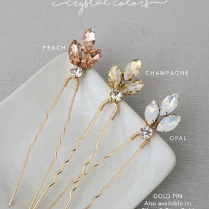 May include: Three gold hair pins with crystal accents. The crystals are in three colors: peach, champagne, and opal. The text "GOLD PIN" is visible at the bottom of the image. The text "Also available in: Silver & Rose Gold" is also visible.
