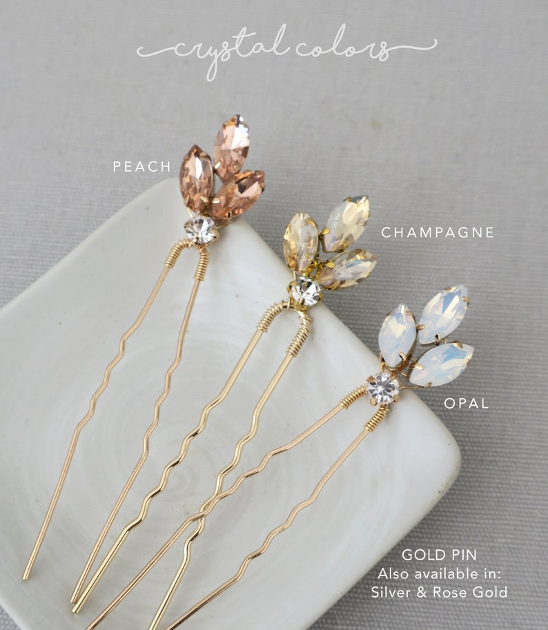 May include: Three gold hair pins with crystal accents. The crystals are in three colors: peach, champagne, and opal. The text "GOLD PIN" is visible at the bottom of the image. The text "Also available in: Silver & Rose Gold" is also visible.