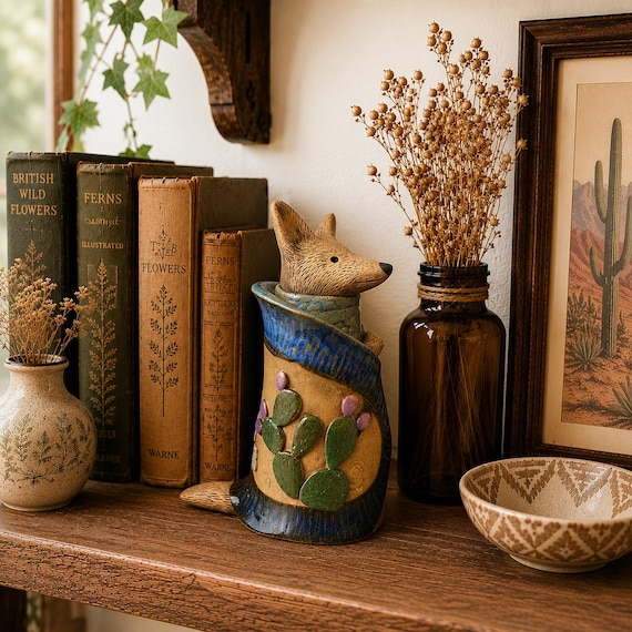 A hand-built ceramic coyote dressed in elaborate painted robes — part folk art, part trickster mythology, 100% a sculpture you'd never find at a big-box store.