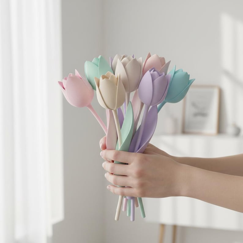 May include: A bouquet of artificial tulips in pastel shades of pink, beige, lavender, and light blue. Each flower features smooth, rounded petals and a long, slender stem with a single leaf attached, creating a soft and uniform appearance.