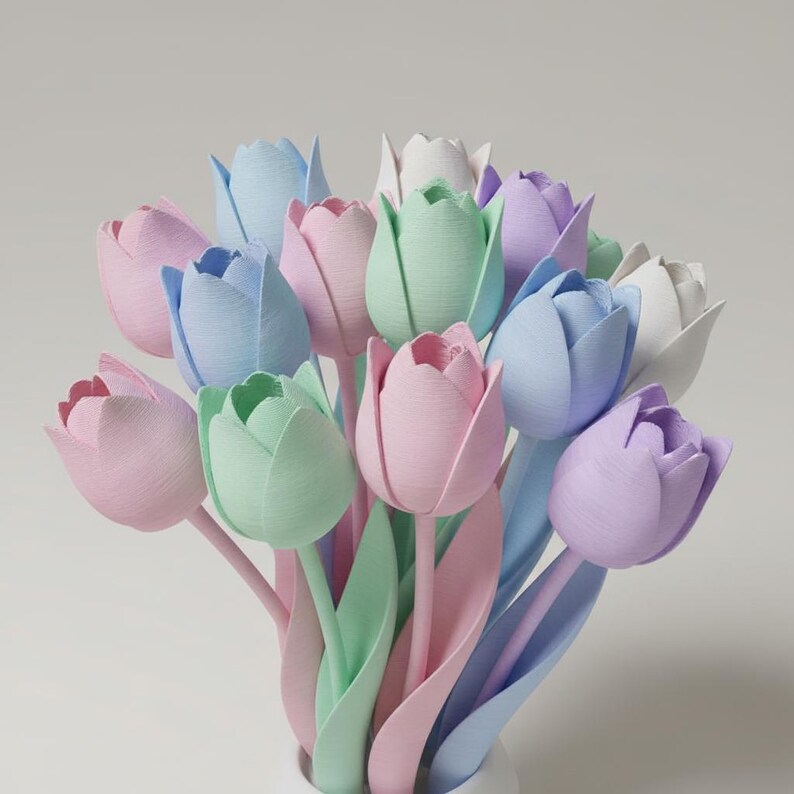 May include: A bouquet of pastel-colored tulips in shades of pink, blue, green, and lavender. The tulips are arranged in a white vase, with the stems and leaves visible. The flowers have a soft, textured appearance.