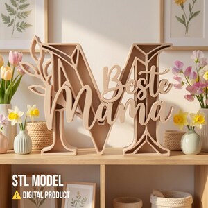 Op de afbeelding: Een lichtbruine houten letter 'M' met de woorden 'Beste Mama' in sierlijke letters. De letter staat op een houten plank. De afbeelding bevat ook de tekst 'STL MODEL' en 'DIGITAL PRODUCT'.