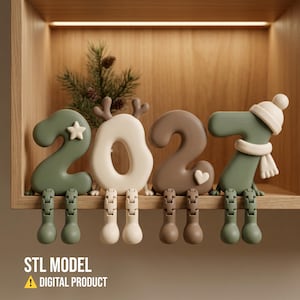 Puede incluir: Un conjunto de cuatro figuras impresas en 3D con forma de números 2, 0, 2 y 7, con piernas articuladas colgantes. Las figuras son de color verde salvia, crema y marrón, decoradas con una estrella, astas, un corazón, un gorro y una bufanda. Texto: STL MODEL DIGITAL PRODUCT.
