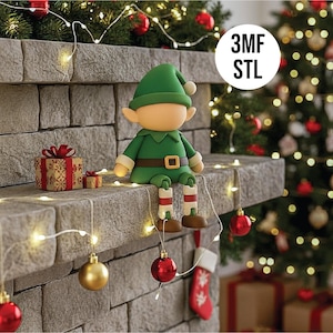 May include: A green elf figurine with a green hat, jacket, and brown shoes sits on a stone ledge. The elf has a tan face and is wearing a brown belt with a gold buckle. The image includes Christmas decorations and the text "3MF STL".