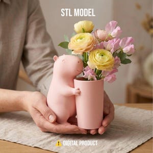 May include: A pink capybara-shaped vase holding a pink cylindrical vase filled with yellow and pink flowers. The text "STL MODEL" is at the top, and "! DIGITAL PRODUCT" is at the bottom.