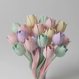 May include: A bouquet of pastel-colored tulips in shades of pink, lavender, yellow, and green. The tulips have long, curved stems and leaves, creating a soft and delicate arrangement. The background is a plain, light gray.
