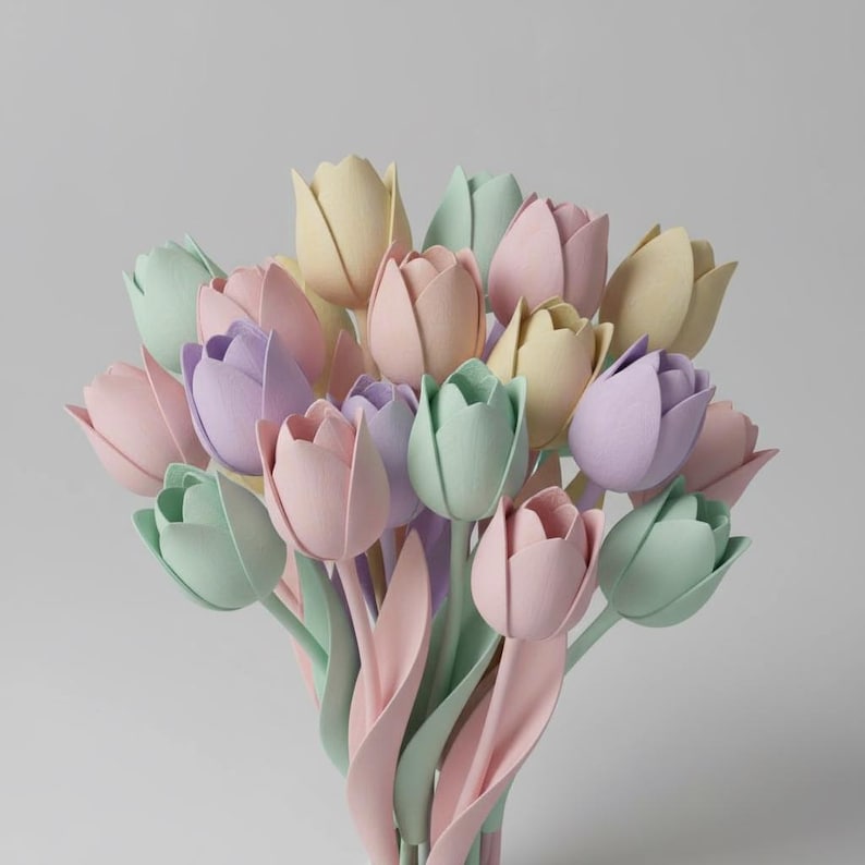 May include: A bouquet of pastel-colored tulips in shades of pink, lavender, yellow, and green. The tulips have long, curved stems and leaves, creating a soft and delicate arrangement. The background is a plain, light gray.