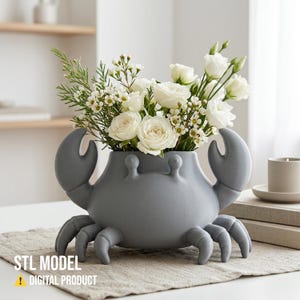 May include: A gray crab-shaped vase filled with white roses and greenery. The vase has a whimsical design with crab claws and legs. The text "STL MODEL ! DIGITAL PRODUCT" is visible on the bottom left.