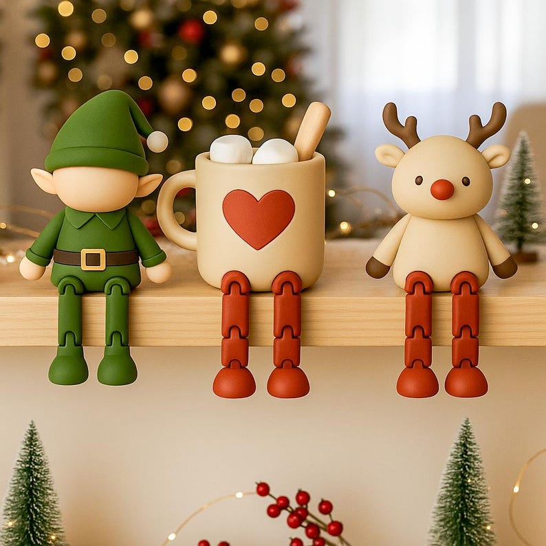 May include: A festive Christmas shelf decoration featuring an elf, a mug of hot cocoa with marshmallows, and a reindeer. The elf is green, the mug is beige with a red heart, and the reindeer is tan. All have dangling red legs.