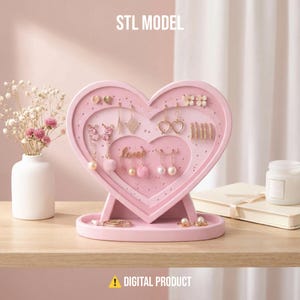 Könnte beinhalten: Ein rosa herzförmiger Schmuck-Organizer mit mehreren Ohrring-Displays und einem kleinen Tablett. Der Organizer trägt oben den Text "STL MODEL" und unten "DIGITAL PRODUCT". Verschiedene Ohrringe sind ausgestellt.