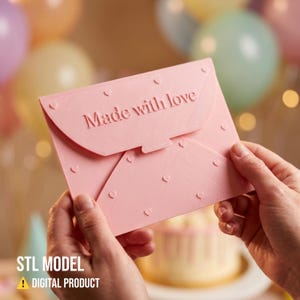 May include: A pink envelope-shaped object with the words "Made with love" embossed on the front. The object is decorated with small heart shapes and held by two hands. The text "STL MODEL" and "DIGITAL PRODUCT" is at the bottom.