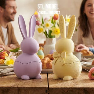 May include: Two decorative Easter bunny figurines. One is lavender, the other is yellow with a bow and floral details. The text "STL MODEL ! DIGITAL PRODUCT" is visible above the bunnies. They are on a wooden table with flowers and food.