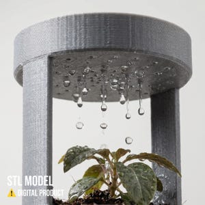 May include: A gray, 3D-printed plant mister with water droplets falling onto a small plant. The structure has a circular top with small holes, supported by vertical columns. The text "STL MODEL" and "DIGITAL PRODUCT" are visible.