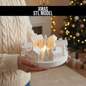 May include: A white ceramic Christmas village candle holder featuring miniature houses and trees. The candle holder has a circular base and is lit by a central candle. The text "XMAS STL MODEL" is displayed above the candle holder.