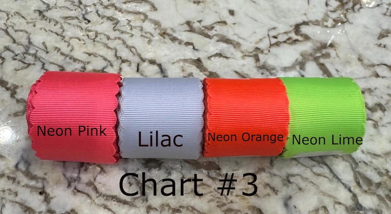 May include: Four rolls of scalloped edge ribbon arranged horizontally, labeled Neon Pink, Lilac, Neon Orange, and Neon Lime. The text Chart #3 is printed below the ribbons, which feature a ribbed texture and vibrant solid colors.