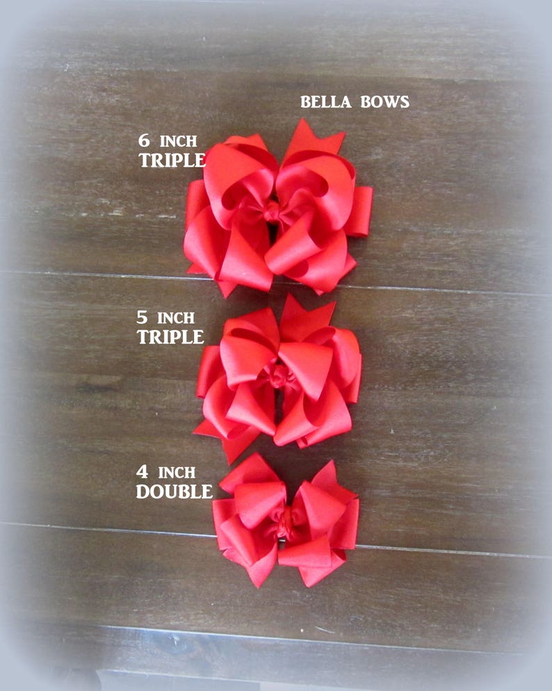 Puede incluir: Se muestran tres lazos rojos para el cabello de diferentes tama&ntilde;os. El m&aacute;s grande es un lazo triple de 6 pulgadas (aproximadamente 15 cm), seguido de un lazo triple de 5 pulgadas (aproximadamente 13 cm) y un lazo doble de 4 pulgadas (aproximadamente 10 cm). El texto "BELLA BOWS" es visible.