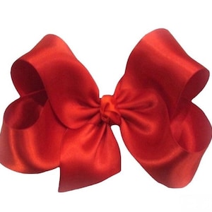 May include: A large, bright red satin bow. The bow is tied in a classic style with two loops and a center knot.