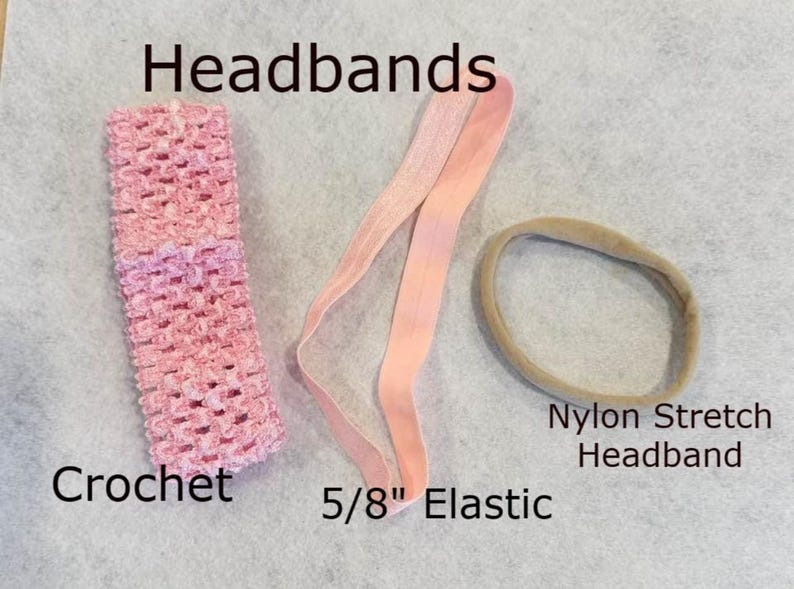 Pu&ograve; includere: Un assortimento di fasce per capelli, tra cui una fascia all'uncinetto rosa, un elastico da 1,6 cm e una fascia elastica in nylon. La fascia all'uncinetto ha un aspetto strutturato e l'elastico &egrave; di colore rosa chiaro.