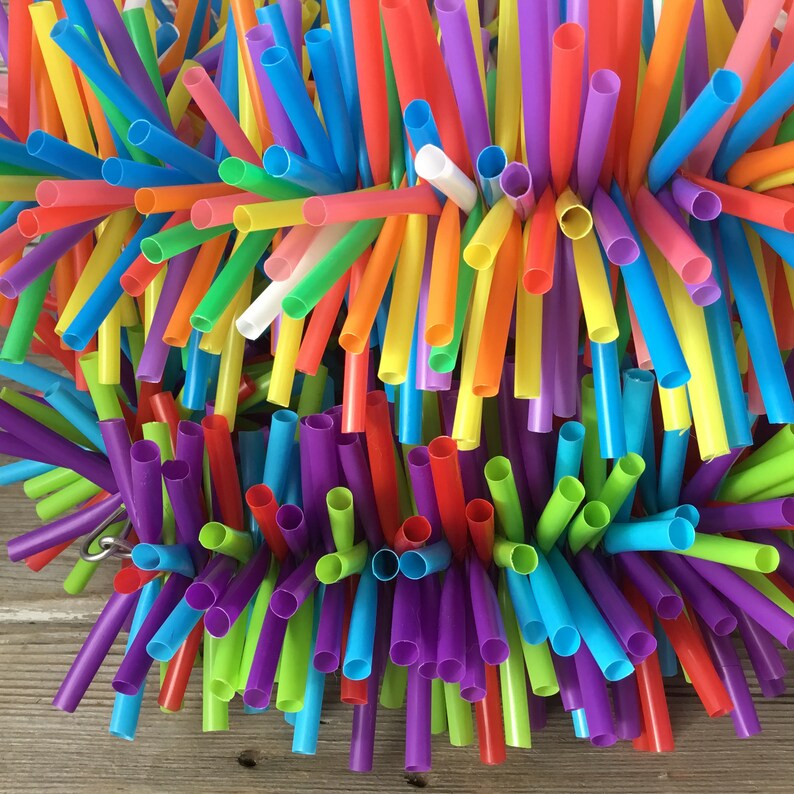 Pu&ograve; includere: Un assortimento colorato di cannucce di plastica in vari colori, tra cui rosso, arancione, giallo, verde, blu, viola e bianco. Le cannucce sono disposte in un motivo circolare, creando una visualizzazione visivamente accattivante e vibrante.