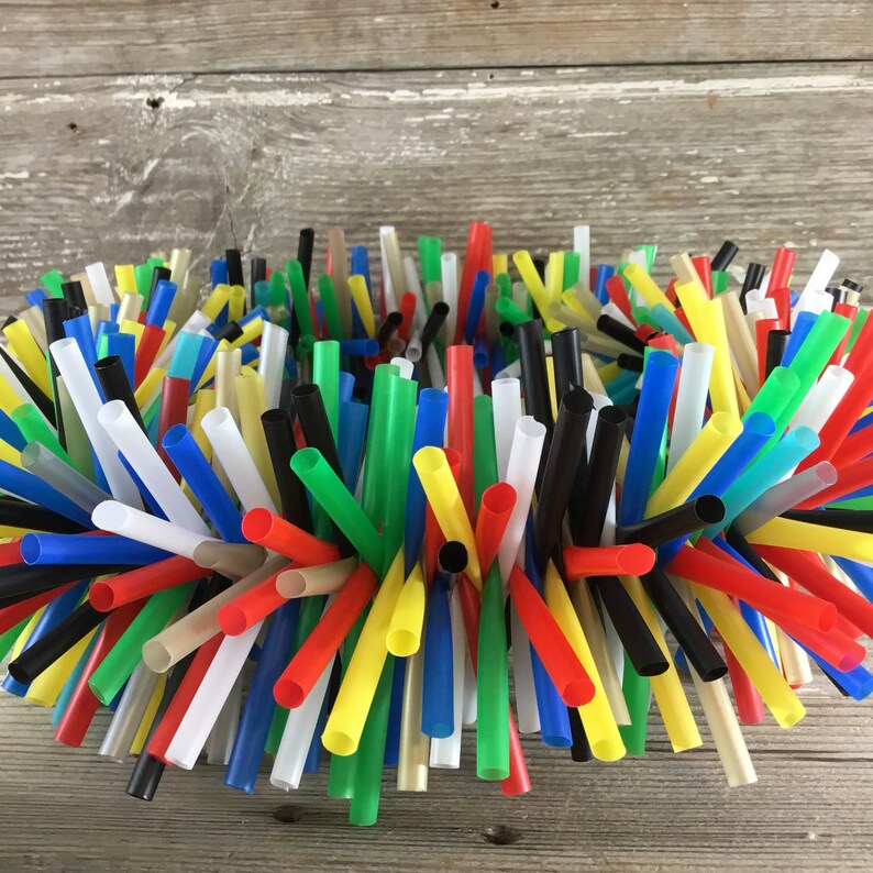 Pu&ograve; includere: Una ghirlanda colorata realizzata con una variet&agrave; di cannucce di plastica per bere. Le cannucce sono disposte in un motivo circolare e sono tenute insieme da un adesivo trasparente. La ghirlanda &egrave; un mix vibrante di cannucce rosse, gialle, blu, verdi, nere e bianche.
