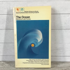 May include: A vintage paperback book titled "The Ocean" with a blue and white wave design on the cover. The book is part of the Bantam/Britannica Books series, with text that reads "Mankind's Last Frontier."
