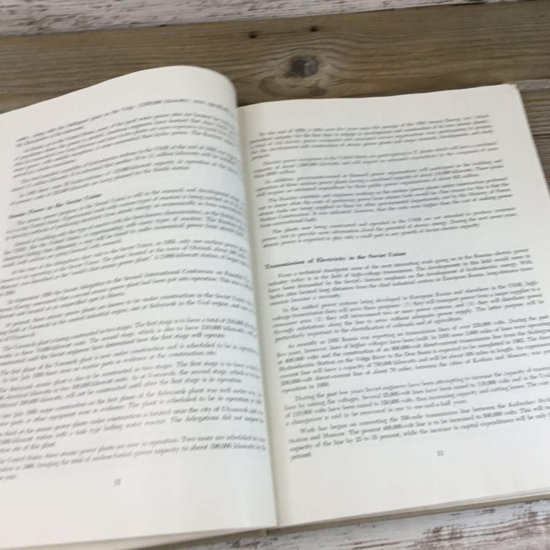 以下が含まれることがあります： 両方のページにテキストが書かれた開いた本。ページはオフホワイトで、テキストは黒です。本は木製の表面に置かれています。テキストは記事またはエッセイのようです。