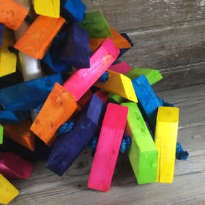 May include: A colorful wooden toy made of brightly colored blocks connected by string. The blocks are painted in shades of blue, green, yellow, orange, pink, and red.