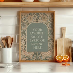 Könnte beinhalten: Ein gerahmter Druck mit floralem Design in einer Küche. Der Druck zeigt einen salbeigrünen Bogen mit dem Text "YOUR FAVORITE QUOTE, LYRIC OR SAYING HERE." Holzutensilien, ein Schneidebrett und ein Glas sind ebenfalls sichtbar.