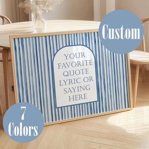 Puede incluir: Una impresión artística enmarcada con un fondo a rayas azules y blancas. La impresión presenta el texto "YOUR FAVORITE QUOTE LYRIC OR SAYING HERE" en forma de arco blanco. También se ven dos círculos azules con las palabras "Custom" y "7 Colors".