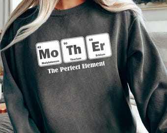 May include: A dark grey sweatshirt with a white graphic of the periodic table elements Mo, Th, and Er, spelling out "Mother". The graphic is labelled with the element names and atomic numbers. The text "The Perfect Element" is printed below the graphic.