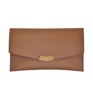 May include: A tan clutch with a gold-colored clasp. The rectangular bag has a flap closure and a minimalist design. The clasp is a geometric shape. The clutch is made of a smooth material.