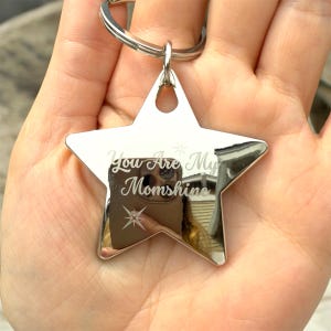 May include: Silver star-shaped keychain with the text "You Are My Momshine" engraved on it.