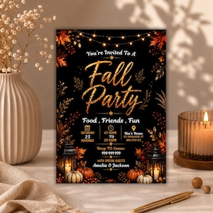 May include: A rectangular invitation card with a black background featuring gold text that reads Fall Party, Food, Friends, Fun, and event details. The design includes string lights, autumn leaves, two black lanterns, and pumpkins at the bottom.