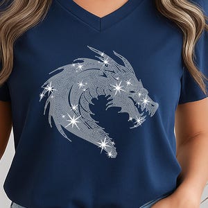 May include: Navy blue V-neck t-shirt featuring a sparkling dragon design. The dragon is depicted in a stylized, glittering pattern, with star-like accents. The shirt is a solid navy color, and the design is centered on the front.
