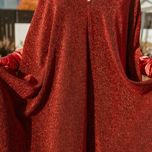 Shimmering, metallic crimson red caftan dress featuring v-neck at front and back.