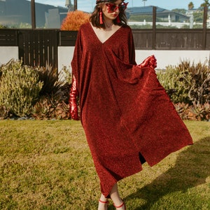 Shimmering, metallic crimson red caftan dress featuring v-neck at front and back.