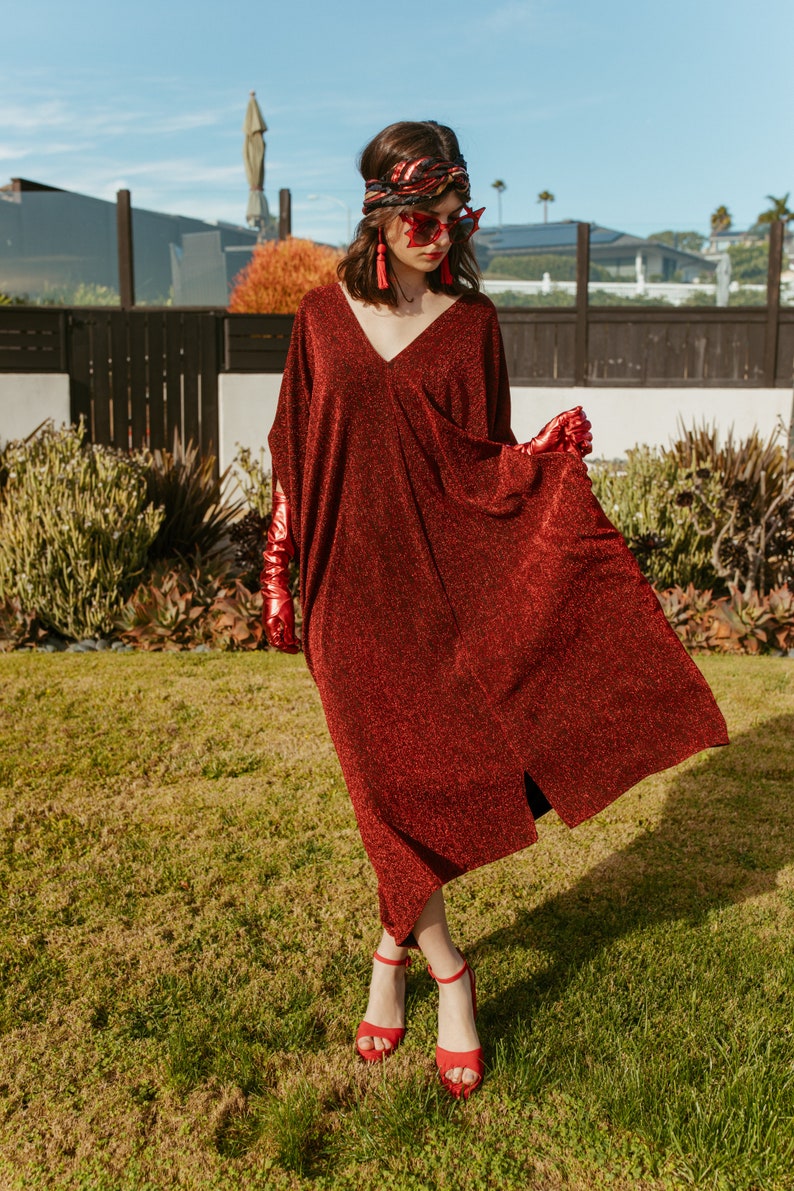 Shimmering, metallic crimson red caftan dress featuring v-neck at front and back.