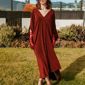 Shimmering, metallic crimson red caftan dress featuring v-neck at front and back.