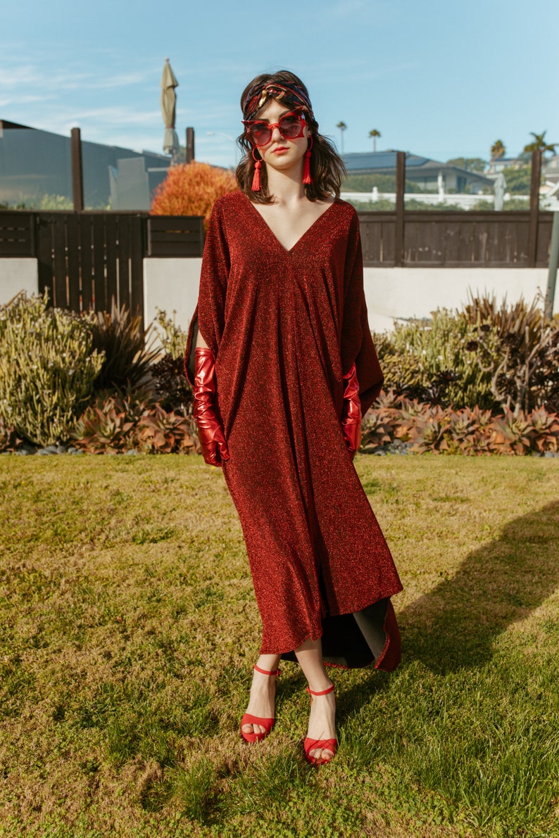 Shimmering, metallic crimson red caftan dress featuring v-neck at front and back.