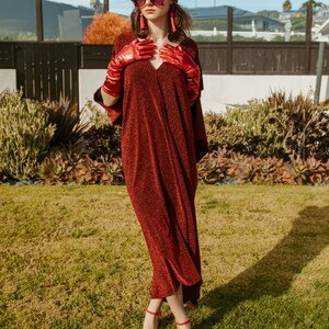 Shimmering, metallic crimson red caftan dress featuring v-neck at front and back.