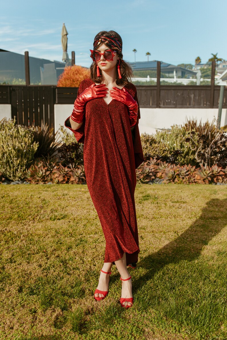 Shimmering, metallic crimson red caftan dress featuring v-neck at front and back.