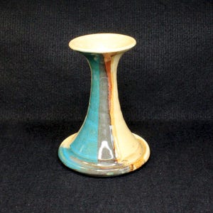 May include: A ceramic vase with a wide base and a narrow neck. The vase is decorated with vertical stripes of blue, gray, brown, and white.