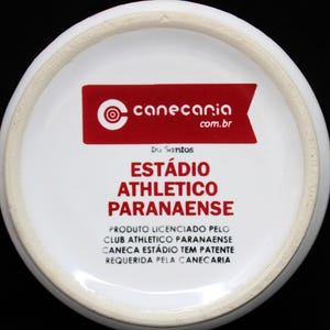 May include: White ceramic mug bottom with red text and logo. The text reads "EST&Aacute;DIO ATHLETICO PARANAENSE" and "canecaria.com.br". The mug is a licensed product of Club Athletico Paranaense.