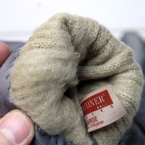 May include: A trio of ceramic mugs with a speckled, matte finish in cream, light grey, and dark grey. Each mug features a simple, minimalist design, ideal for tea or coffee.